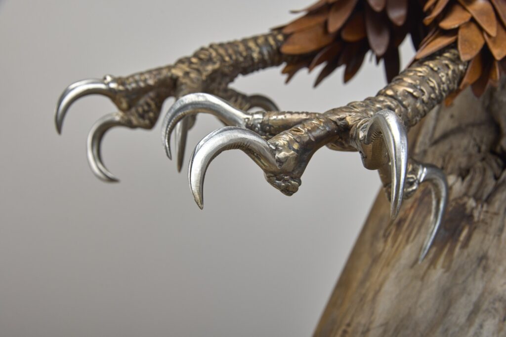 Steel eagle talons gripping driftwood
