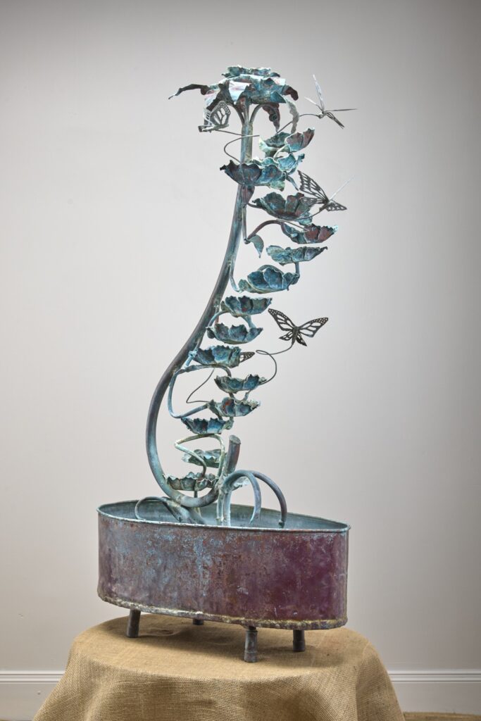 Verdigris vine fountain with leaves and butterflies over a copper basin