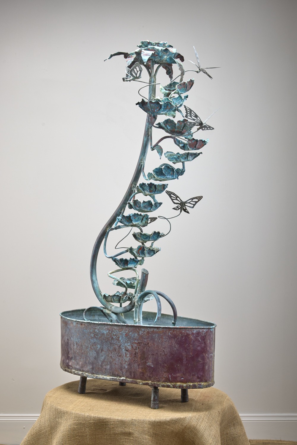 Verdigris vine fountain with leaves and butterflies over a copper basin